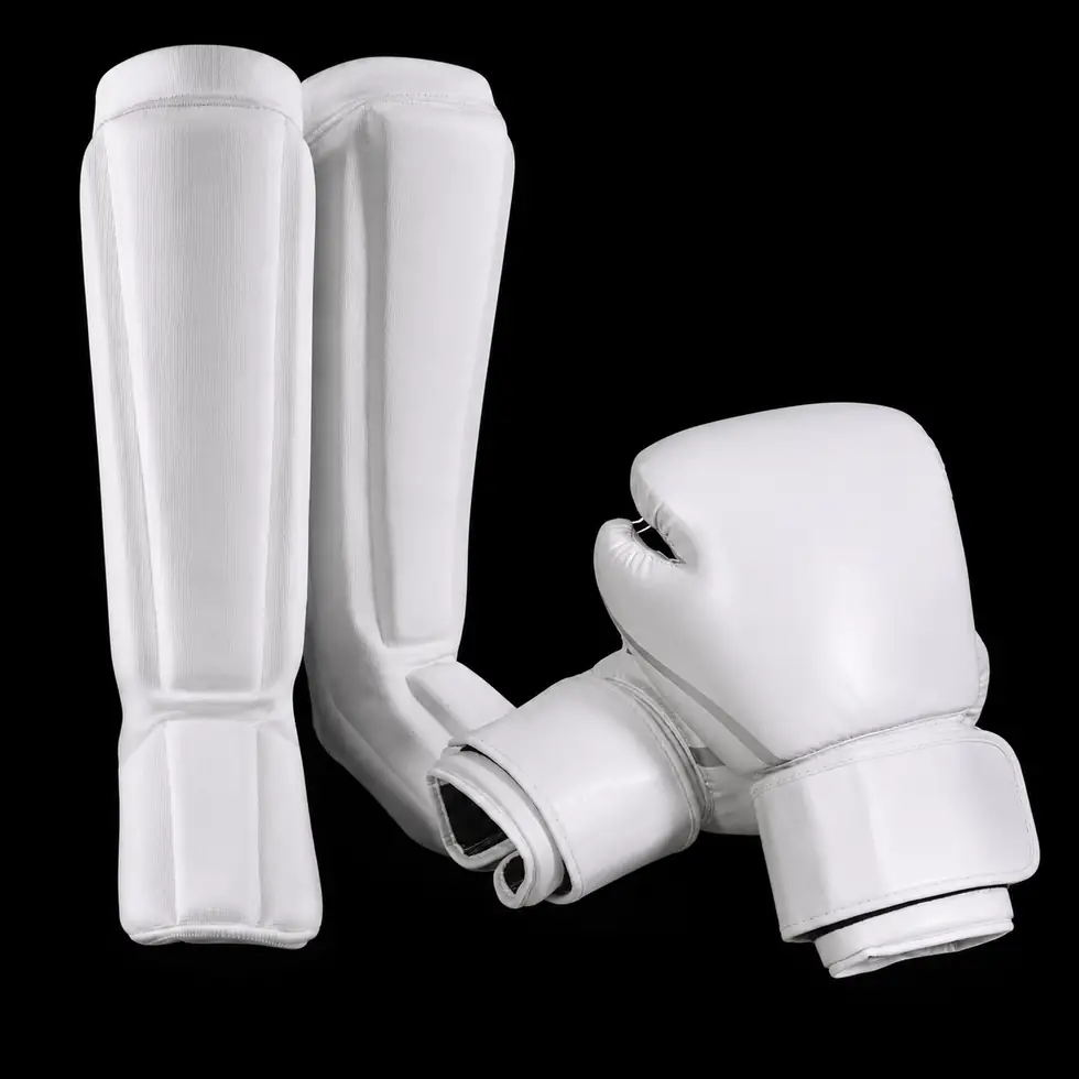 White kickboxing gloves and protective gear for women’s class contact drills